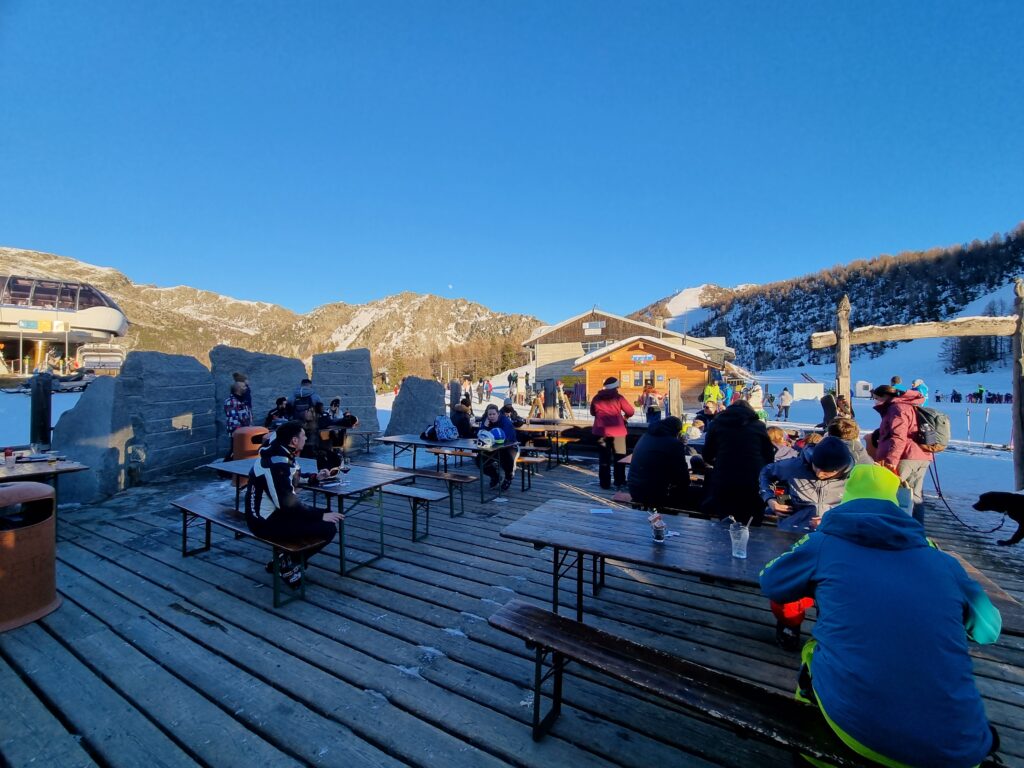 발말렌코 스키장 정상 카페에서 사람들이 와인과 맥주를 즐기고 있다.